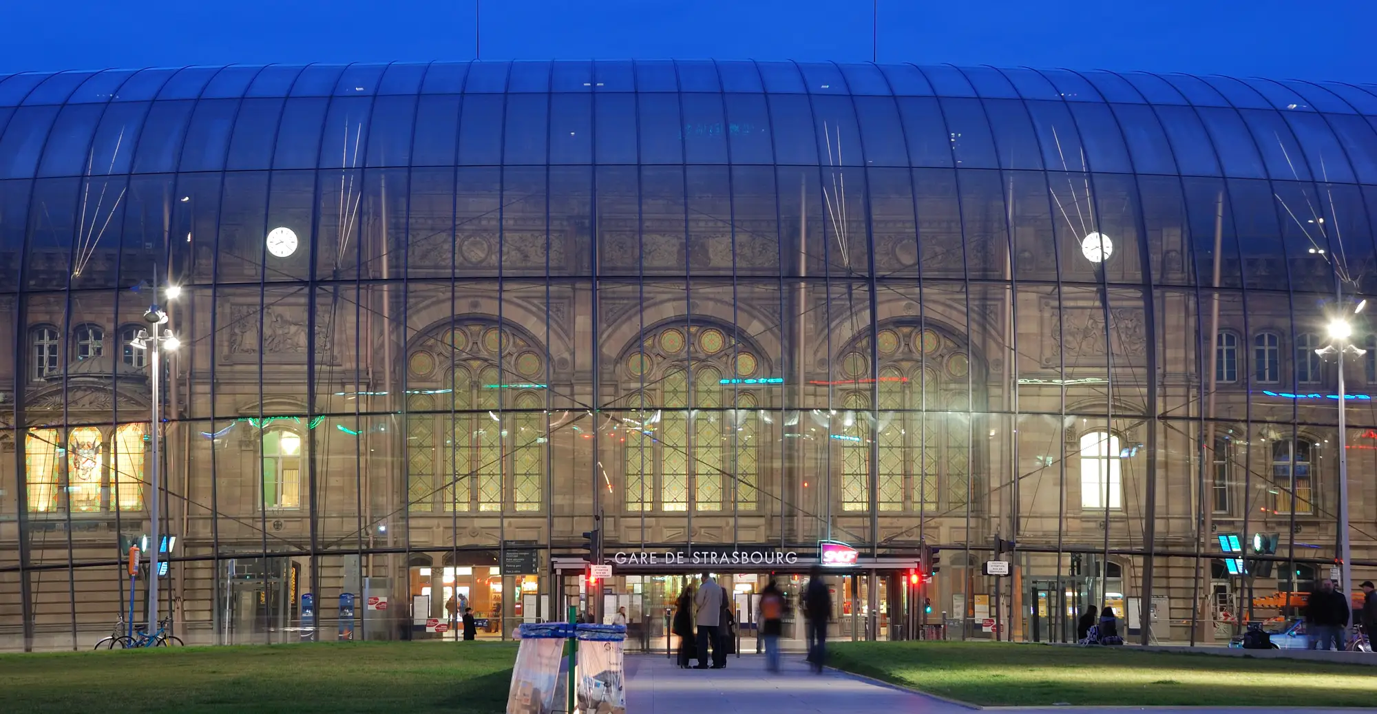 Der Straßburger Hauptbahnhof in der Abenddämmerung, die Glashülle vor der Sandsteinfassade von 1883