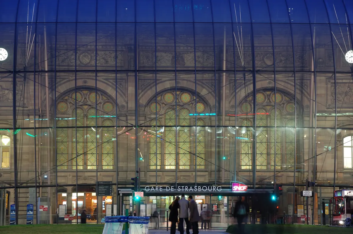 Strasbourg station lit at night, the station sign readable under the glass canopy